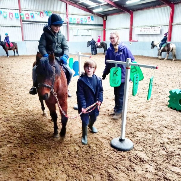 group of children playing games while riding ponies