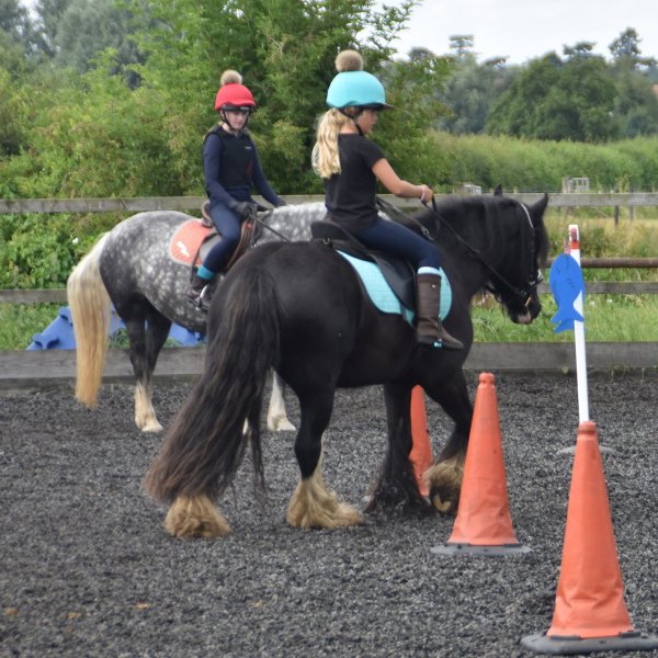 horse riders weaving round cones