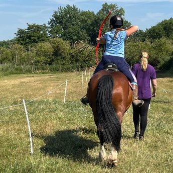 Back view of shooting arrows from a horse
