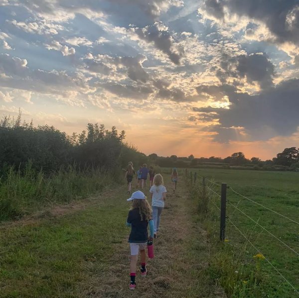 children walking along farm track at sunset